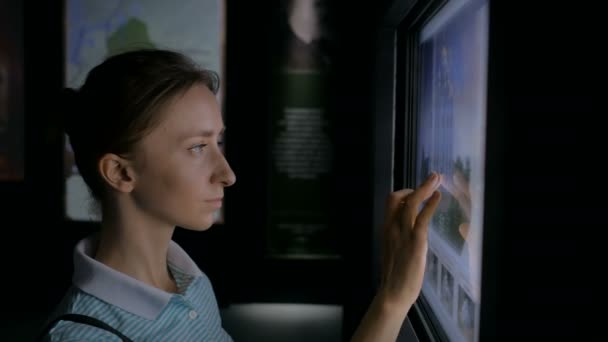 Woman using interactive touchscreen display at modern history museum — Stock Video