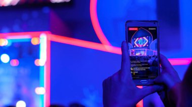 Akıllı telefonlu canlı müzik konserinin görüntülerini kaydeden eller.