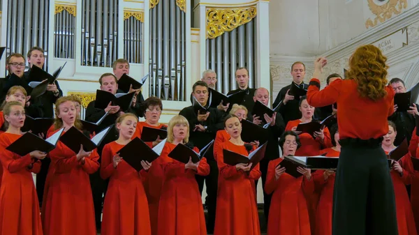 Koroda şarkı söyleyen bir grup insan.