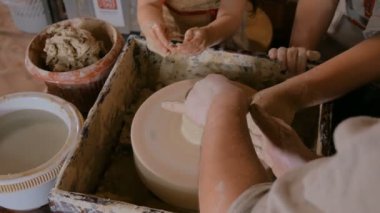 Potter çömlek atölyesinde seramik ile nasıl çalışılacağını gösteriyor.