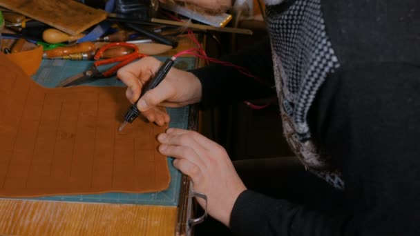 Skinner making decorative details on leather playing field — Stock Video