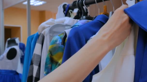 Woman hand sorts out hanger with clothes — Stock Video