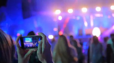 Akıllı telefonlu canlı müzik konserinin görüntülerini kaydeden eller.