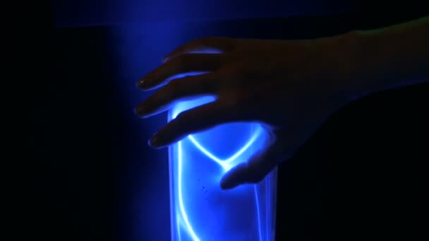 Женщина касается плазменной стеклянной колбы — стоковое видео