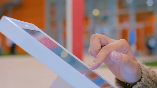 Şehir sergisinde etkileşimli dokunmatik ekran kullanan kadın