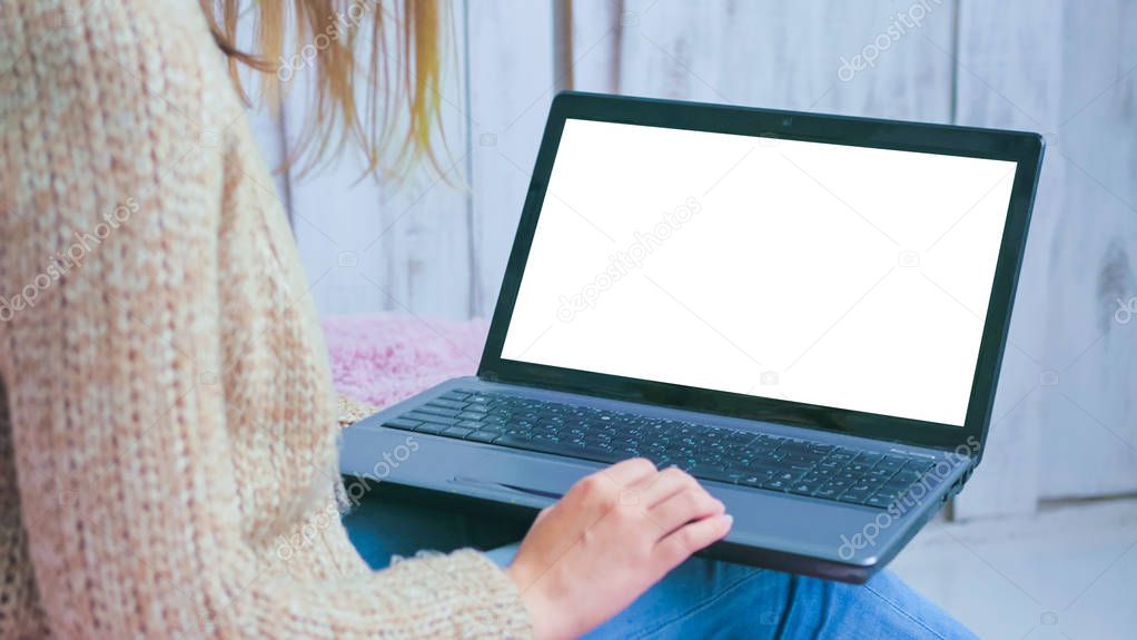 Woman using laptop with white empty display