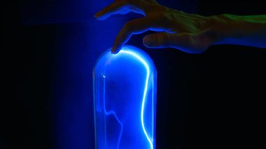 Kadın plazma cam şişesine dokunuyor.