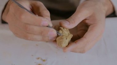 Potter, masa oyunu için kil figürü yapıyor