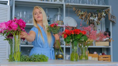 Çiçekçide düğün kompozisyonu hazırlayan profesyonel bir çiçekçi.