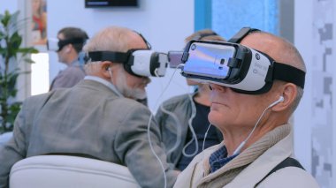 Yaşlılar sanal gerçeklik kulaklığı kullanıyor.
