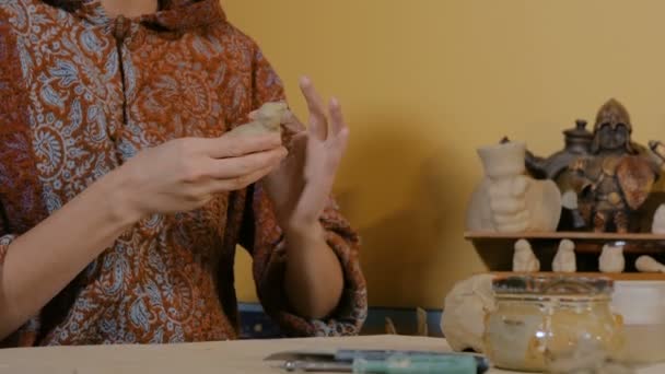 Женщина гончар, делающая керамические сувенирные пенни свисток в керамической мастерской — стоковое видео
