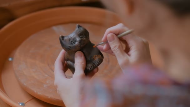Profesionální potter malba suvenýrové keramické penny whistle v keramické dílně — Stock video