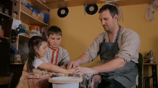 Töpfer zeigt im Töpferatelier, wie man mit Keramik arbeitet — Stockvideo