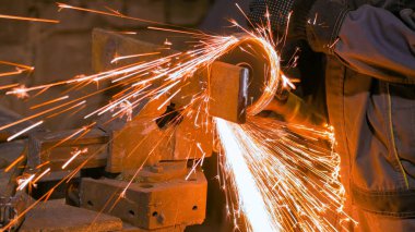 Demirci el testeresiyle metal kesiyor.