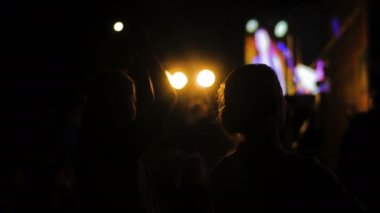 Elektronik müzik konserinde sahne önünde alkışlar kadınlar siluet