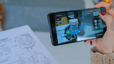 Artırılmış gerçeklik uygulaması olan akıllı telefon kullanan kadın