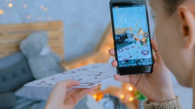 Artırılmış gerçeklik uygulaması olan akıllı telefon kullanan kadın