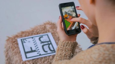 Artırılmış gerçeklik app ile akıllı telefon kullanan kadın sanal ev planı kontrol