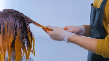 Profesyonel kuaför kadın istemcisinin stüdyoda saç boyama