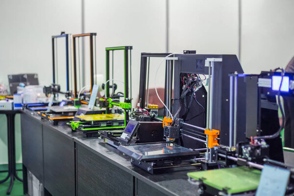 Three dimensional 3D printers during work at modern technology exhibition