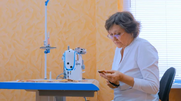 Женщина дизайнер швейная одежда с швейной машинкой в ателье — стоковое фото