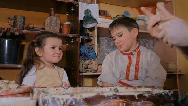Töpfer zeigt im Töpferatelier, wie man mit Keramik arbeitet — Stockvideo