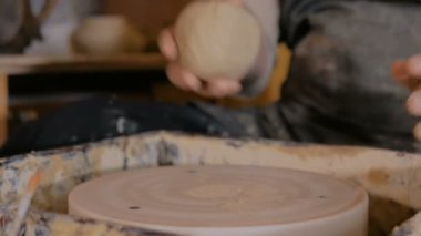 Profesyonel erkek çömlekçi işe kil hazırlıyor.