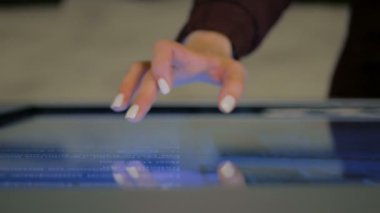 Teknoloji sergisinde etkileşimli dokunmatik ekran kullanan kadın