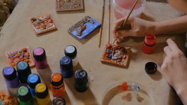 Professionele vrouw potter schilderij keramiek souvenir magneet in de pottenbakkerij — Stockvideo