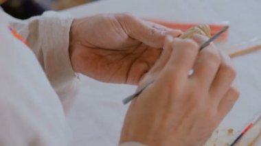 Potter, masa oyunu için kil figürü yapıyor