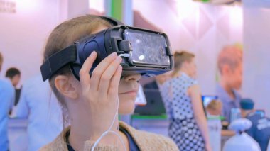 Sanal gerçeklik gözlüğü kullanan genç bir kadın.