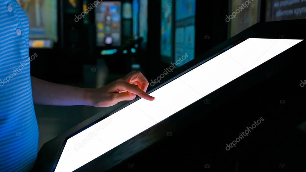 Woman using interactive empty white touchscreen display