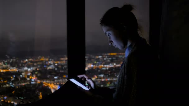 Vrouw die 's nachts verticale zwarte smartphone gebruikt — Stockvideo