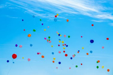 Gökyüzünde bir sürü renkli balon uçuşuyor.