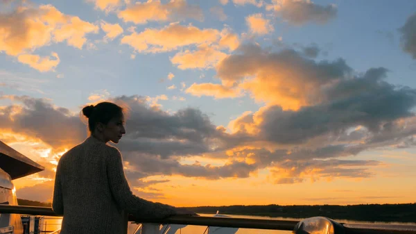 Frau bewundert Sonnenuntergang vom Deck des Kreuzfahrtschiffes — Stockfoto