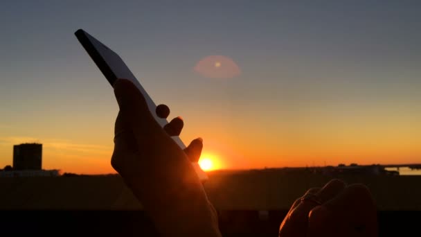 Žena silueta pomocí smartphone ve městě při západu slunce — Stock video