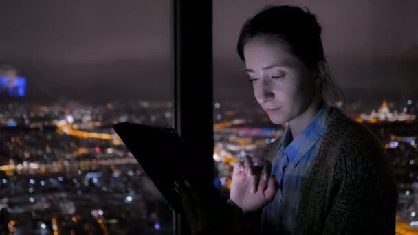Frau benutzt nachts schwarzes digitales Tablet — Stockvideo