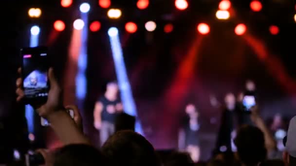 People hands silhouette recording video of live music concert with smartphone — Stock Video