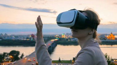 Kadın sanal gerçeklik gözlük güneş battıktan sonra şehirde kullanır