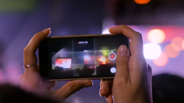 Kvinnliga händer Silhuett inspelning video av levande musik konsert med smartphone — Stockvideo