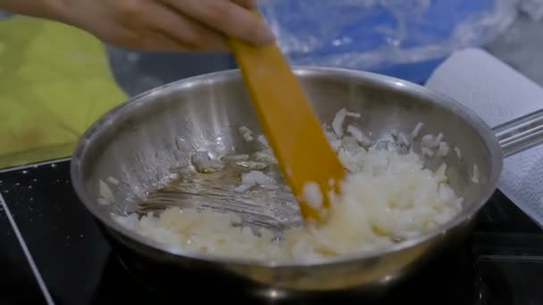 Цибуля смажить і розкладається в сковороді — стокове відео
