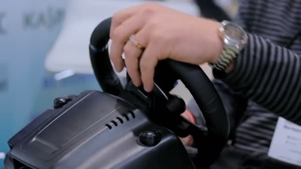 Man using gaming steering wheel joystick at technology exhibition — Stock Video