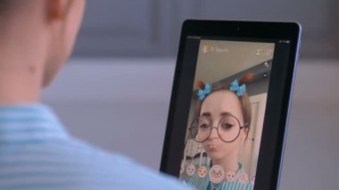 Akıllı telefonda yüz maskesi ile Snapchat Multimedya mesajlaşma uygulamasını kullanan kadın