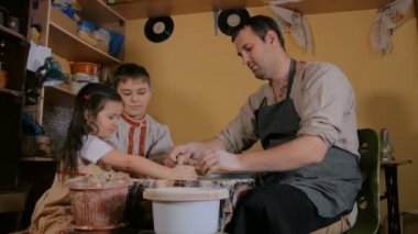 Potter çömlek atölyesinde seramik ile nasıl çalışılacağını gösteriyor.