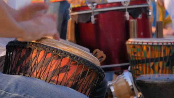 Группа людей, играющих на этнических барабанах на улице — стоковое видео