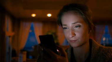 Kafede akıllı telefon kullanan bir kadın.