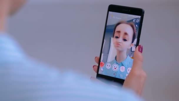 Vrouw met behulp van Snapchat multimedia messaging app met Face Mask op smartphone — Stockvideo