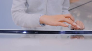 Teknoloji sergisinde etkileşimli dokunmatik ekran kullanan kadın