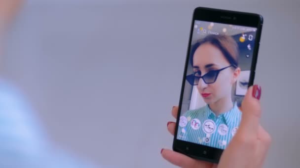 Donna che utilizza Snapchat app di messaggistica multimediale con maschera facciale su smartphone — Video Stock