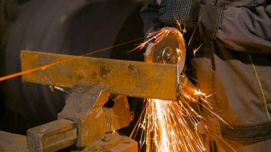 Demirci el testeresiyle metal kesiyor.